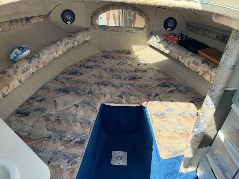 Slide: The Image of 1996 Sea Ray 215 Express Cruiser cabin interior with patterned upholstery and storage compartments. - 28