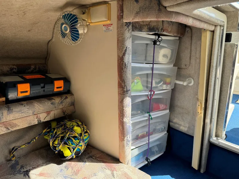 Slide: The Image of Interior of 1996 Sea Ray 215 Express Cruiser with storage and fan. - 29