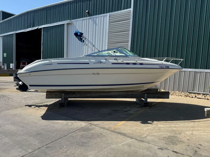 Slide: The Image of 1996 Sea Ray 215 Express Cruiser boat on a stand outside a green warehouse. - 3