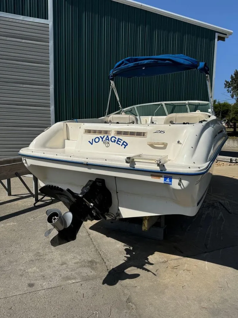 Slide: The Image of 1996 Sea Ray 215 Express Cruiser boat with blue canopy, docked outdoors. - 7
