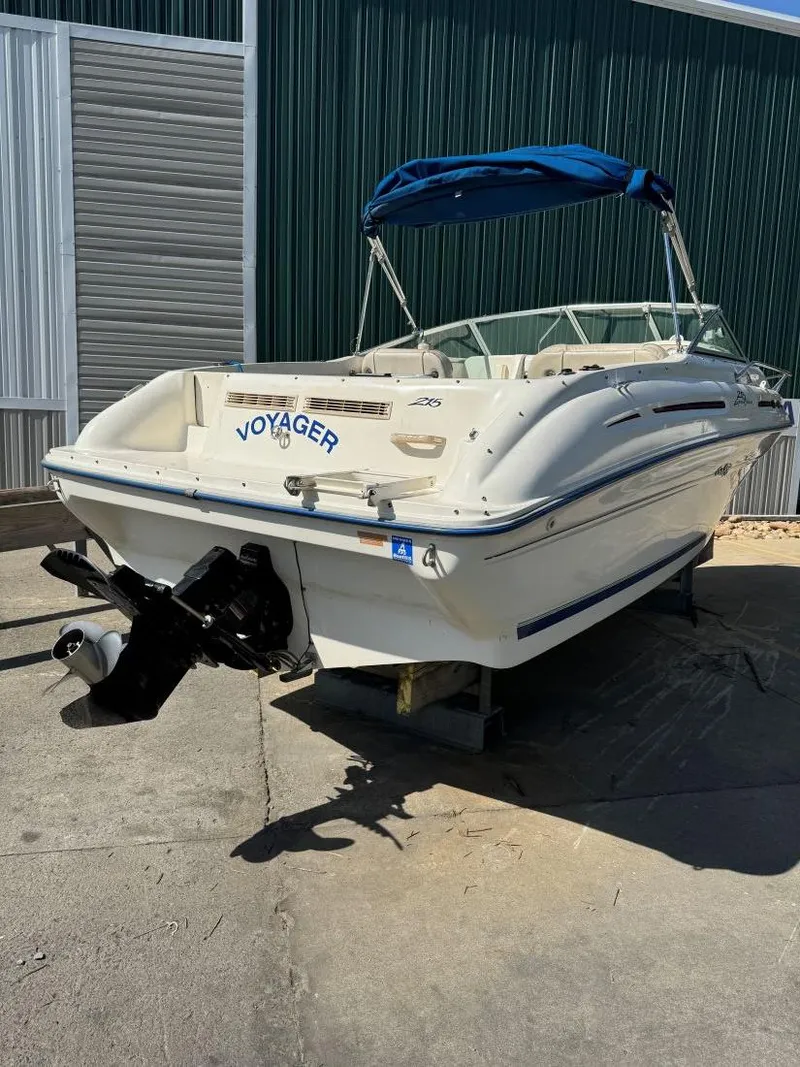 Slide: The Image of 1996 Sea Ray 215 Express Cruiser boat with blue canopy, docked outdoors. - 8