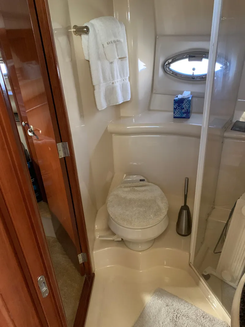 Slide: The Image of 2006 Meridian 459 Motoryacht bathroom with toilet, towel, and porthole window. - 12
