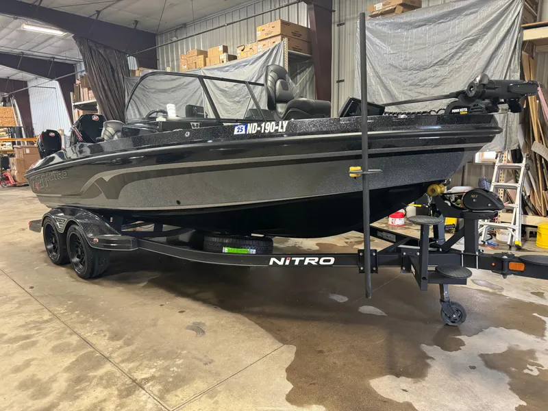 Slide: The Image of 2022 Nitro ZV20 boat in a garage, black exterior, on a trailer. - 2