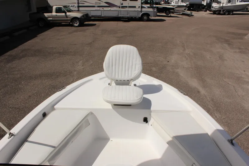 Slide: The Image of 2002 Cobia 191 Bay boat with white seating, parked in a lot. - 16