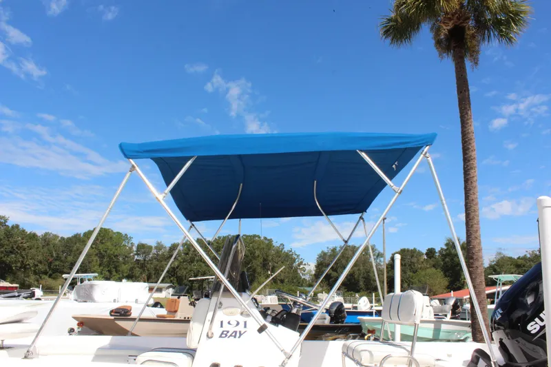 Slide: The Image of 2002 Cobia 191 Bay boat with blue canopy under clear sky. - 27