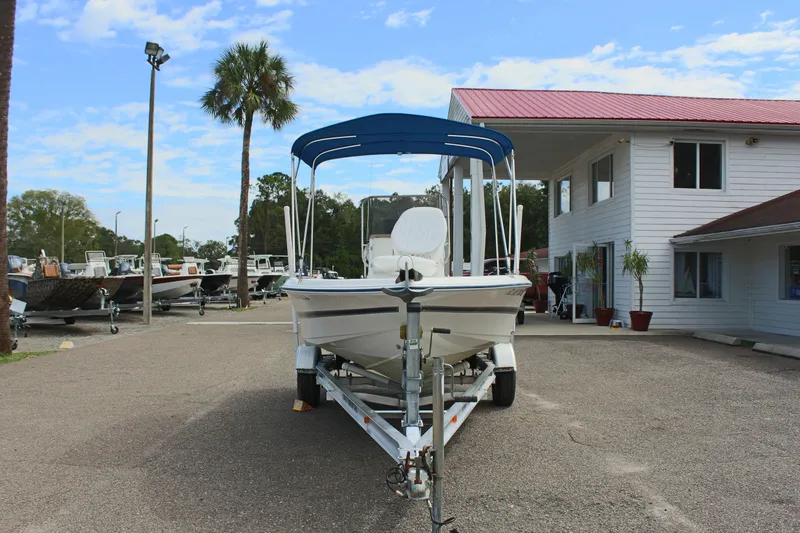 Slide: The Image of 2002 Cobia 191 Bay boat on trailer, parked outside a building. - 28