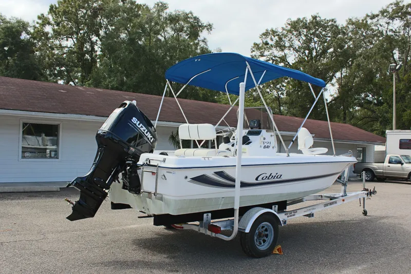 Slide: The Image of 2002 Cobia 191 Bay boat with Suzuki outboard motor on trailer. - 5