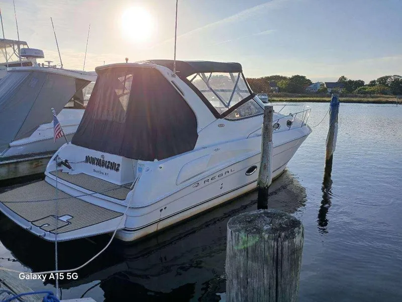 Slide: The Image of 2002 Regal Commodore 3060 boat docked at sunset, calm water, rear view. - 0