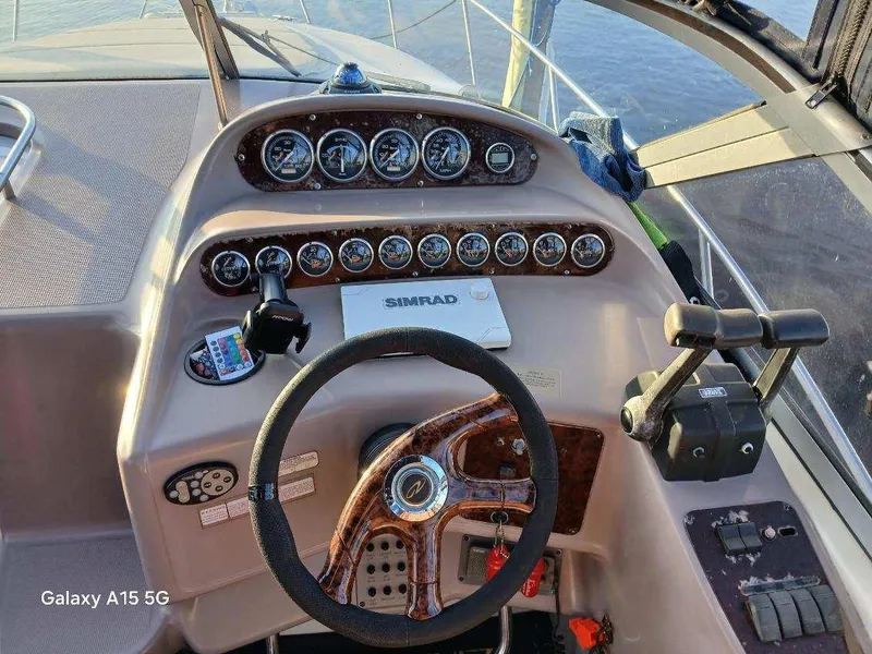 Slide: The Image of 2002 Regal Commodore 3060 boat dashboard with steering wheel and instrument panel. - 14