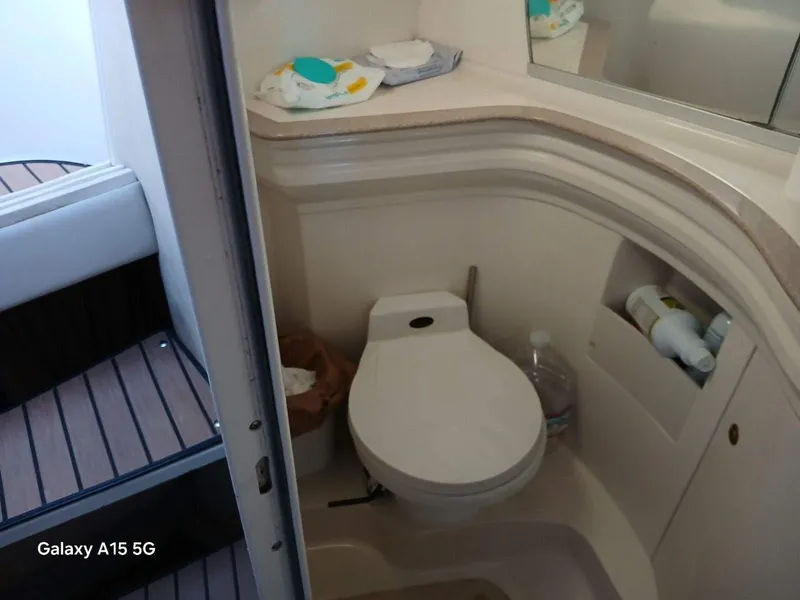 Slide: The Image of Compact bathroom in 2002 Regal Commodore 3060 boat with toilet and storage shelves. - 16
