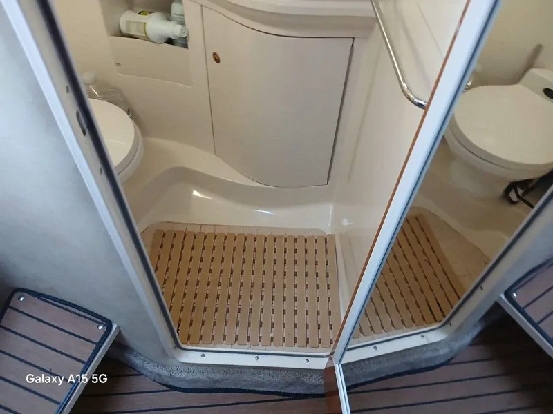 Slide: The Image of Bathroom interior of 2002 Regal Commodore 3060 boat with wooden mat and toilet. - 17