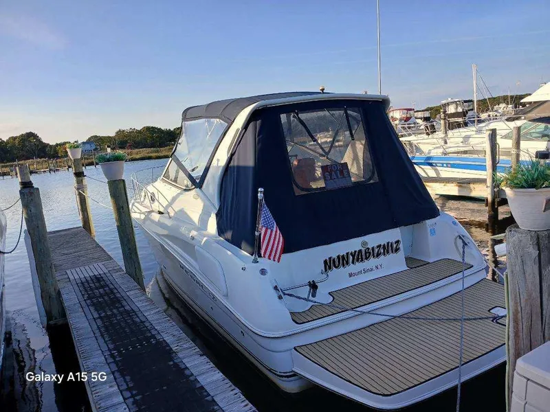 Slide: The Image of 2002 Regal Commodore 3060 boat docked at marina with American flag. - 2