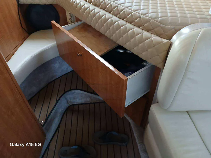 Slide: The Image of Interior of 2002 Regal Commodore 3060 boat with open wooden drawer and cushioned seating. - 22