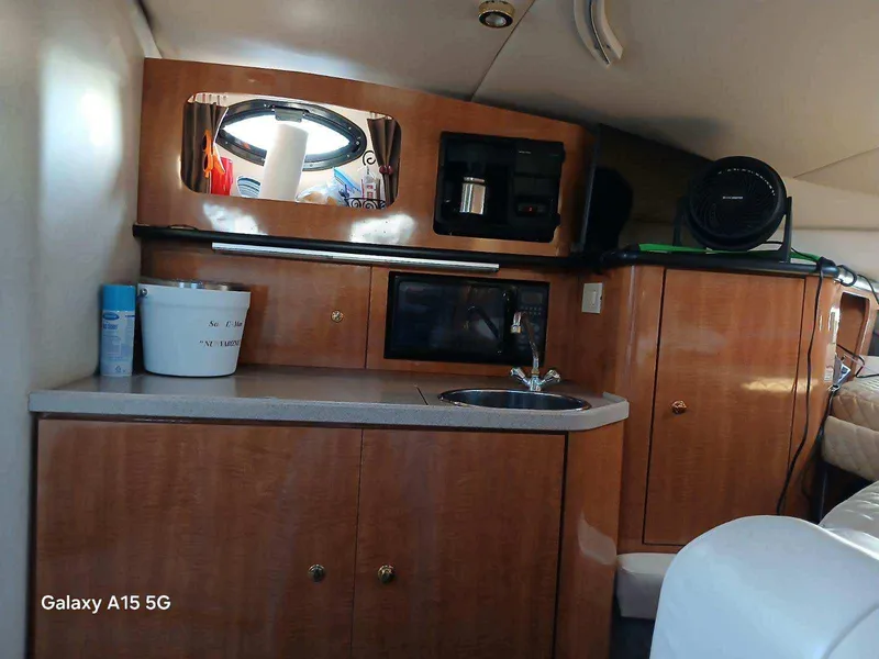 Slide: The Image of Interior of 2002 Regal Commodore 3060 boat with kitchenette and wooden cabinetry. - 24