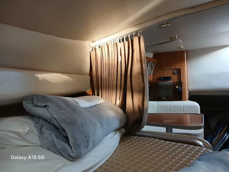 Slide: The Image of Cozy cabin interior of 2002 Regal Commodore 3060 with bed and curtain. - 25