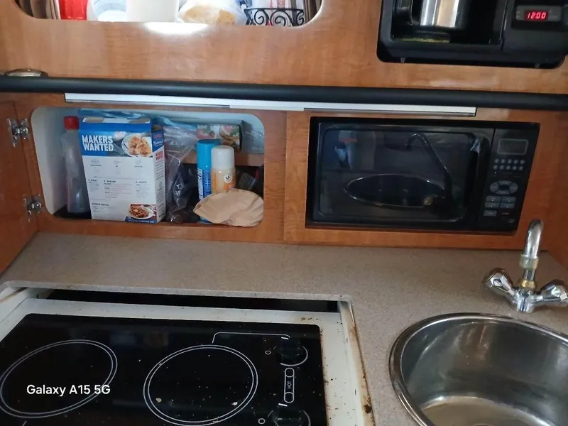 Slide: The Image of 2002 Regal Commodore 3060 kitchen with microwave, stove, and sink. - 28