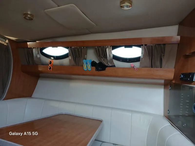 Slide: The Image of Interior of 2002 Regal Commodore 3060 boat with seating and porthole windows. - 30