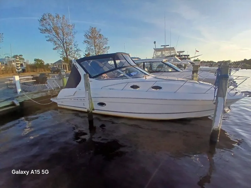 Slide: The Image of 2002 Regal Commodore 3060 boat docked in a marina, calm water, clear sky. - 4