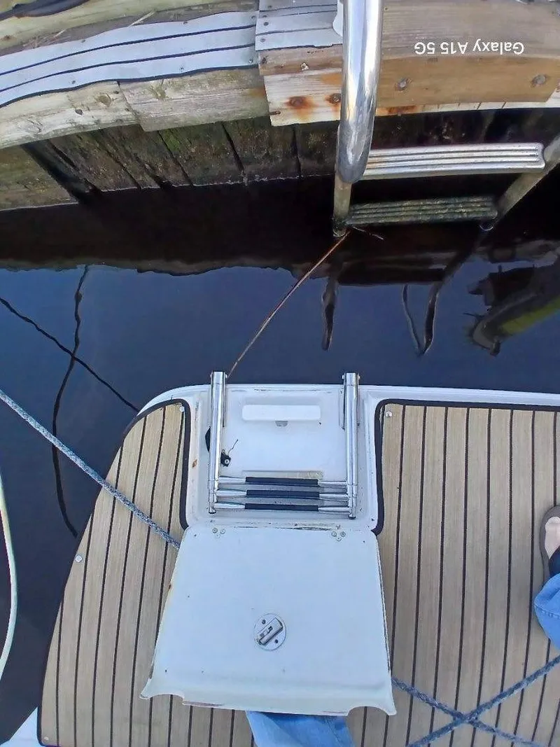 Slide: The Image of View from a 2002 Regal Commodore 3060 boat, showing a swim platform and dock ladder. - 41
