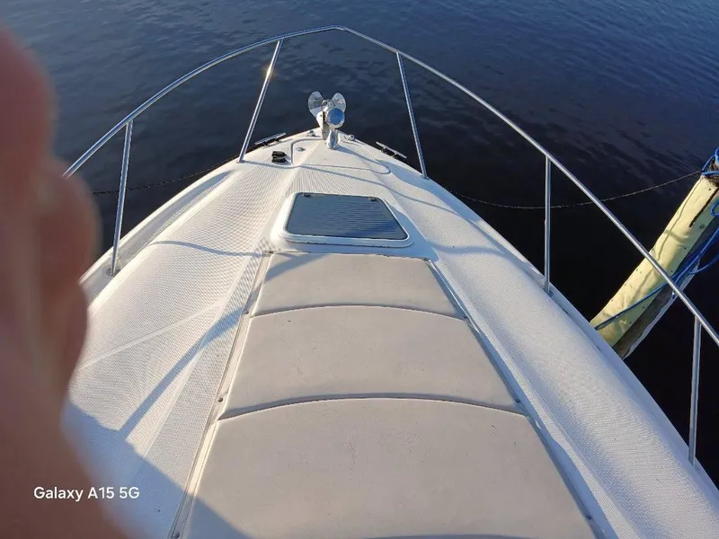 Slide: The Image of Bow view of 2002 Regal Commodore 3060 boat on calm water. - 5