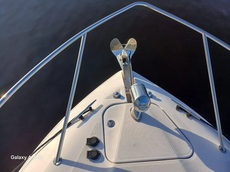 Slide: The Image of Bow of 2002 Regal Commodore 3060 boat with anchor, railing, and textured deck. - 6