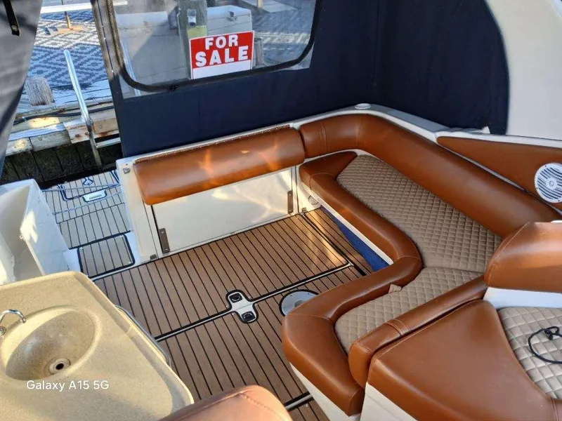 Slide: The Image of 2002 Regal Commodore 3060 boat interior with brown seating, for sale sign visible. - 7