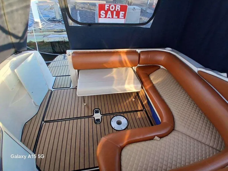 Slide: The Image of 2002 Regal Commodore 3060 boat interior with brown seating, wood flooring, and "For Sale" sign. - 8