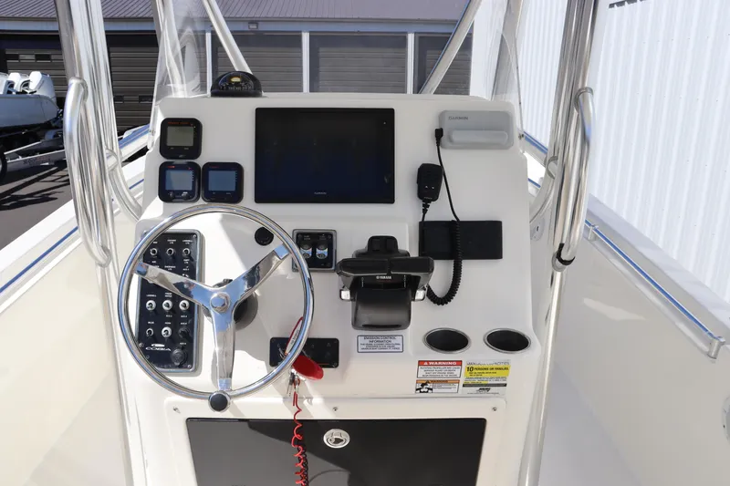 Slide: The Image of 2012 Cobia 256 CC boat console with steering wheel and navigation controls. - 11