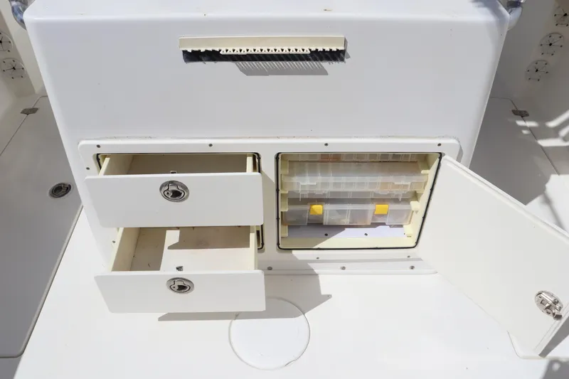 Slide: The Image of 2012 Cobia 256 CC boat storage compartments with drawers and tackle box. - 19
