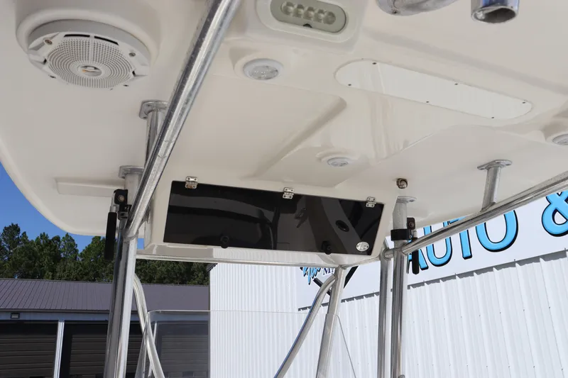 Slide: The Image of 2012 Cobia 256 CC boat T-top with speakers and rod holders. - 22