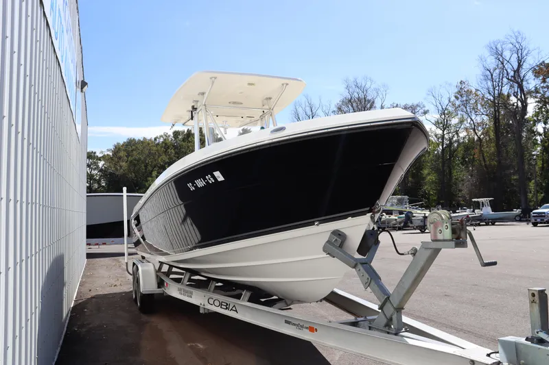 Slide: The Image of 2012 Cobia 256 CC boat on trailer, parked outdoors. - 3