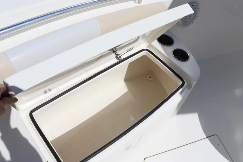 Slide: The Image of Open storage compartment on 2012 Cobia 256 CC boat with cup holders. - 32