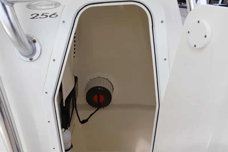 Slide: The Image of 2012 Cobia 256 CC boat storage compartment with open door. - 33