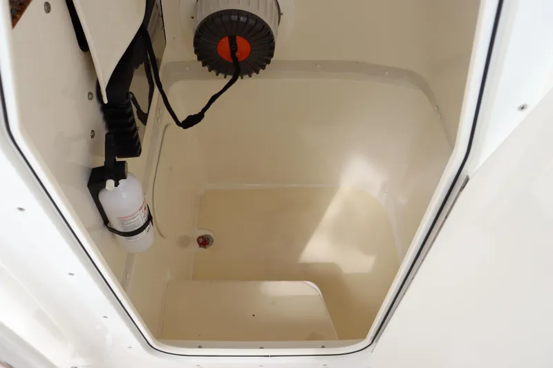 Slide: The Image of 2012 Cobia 256 CC storage compartment interior with pump and wiring. - 34