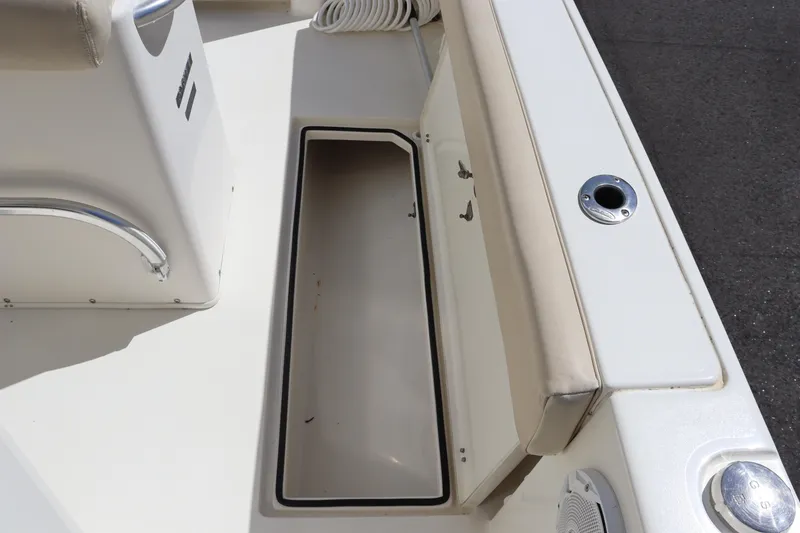 Slide: The Image of 2012 Cobia 256 CC boat interior storage compartment with cushioned seating. - 37