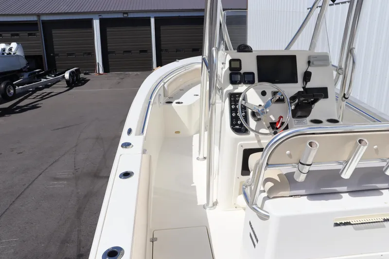 Slide: The Image of 2012 Cobia 256 CC boat interior with steering console and storage compartments. - 43