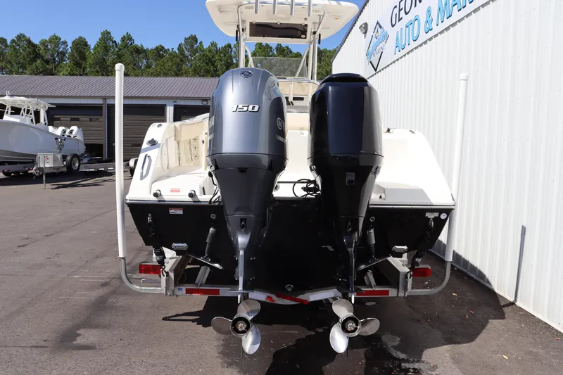 Slide: The Image of 2012 Cobia 256 CC boat with dual outboard motors in a marina setting. - 45