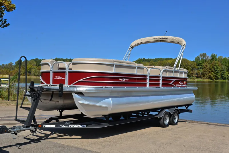 Slide: The Image of 2018 Sun Tracker Party Barge 24 DLX pontoon boat on trailer by a lake. - 10