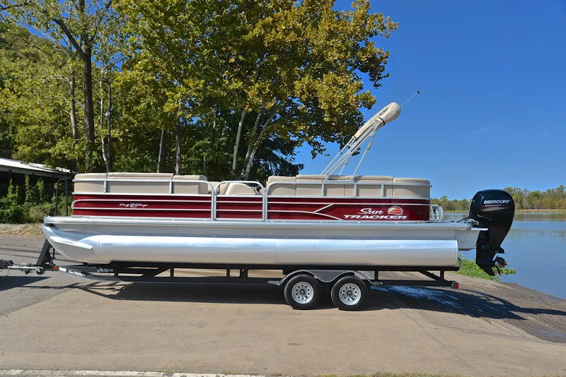 Slide: The Image of 2018 Sun Tracker Party Barge 24 DLX pontoon boat on trailer by a lake. - 11