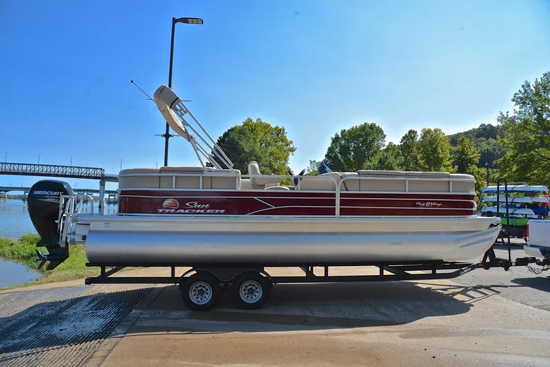 Slide: The Image of 2018 Sun Tracker Party Barge 24 DLX pontoon boat on trailer by a river. - 15