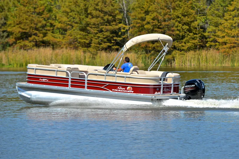 Slide: The Image of 2018 Sun Tracker Party Barge 24 DLX cruising on a serene lake. - 4