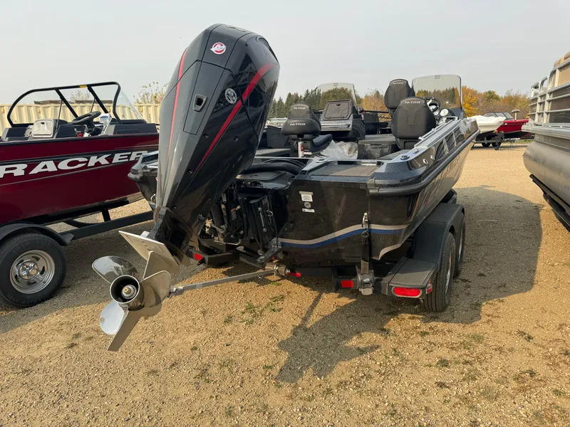 Slide: The Image of 2024 Nitro ZV20 boat with powerful outboard motor, parked on gravel. - 4