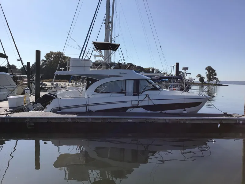 Slide: The Image of 2024 Beneteau Antares 11 Fly yacht docked at marina, side view. - 0