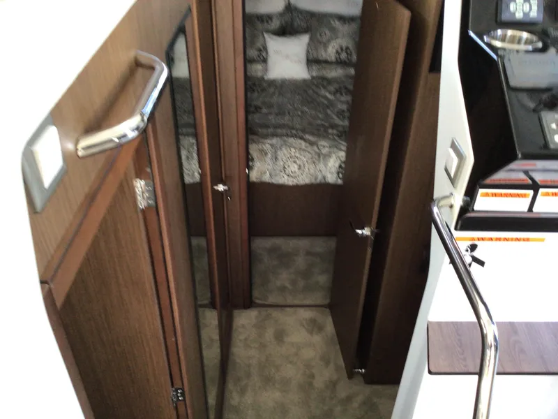 Slide: The Image of 2024 Beneteau Antares 11 Fly interior cabin with wood finish and cozy bedding. - 12