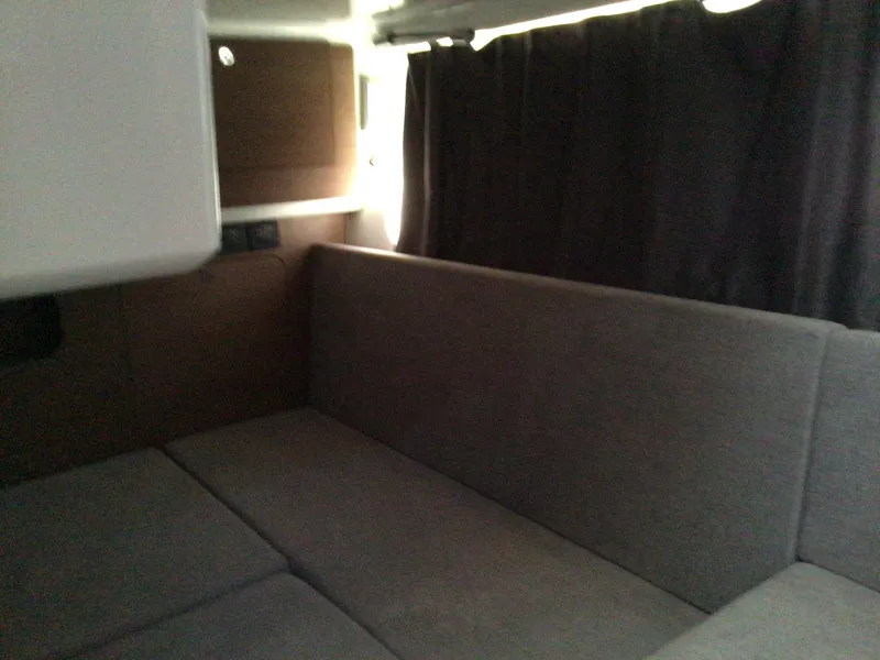 Slide: The Image of Interior cabin of 2024 Beneteau Antares 11 Fly with gray seating and dark curtains. - 13