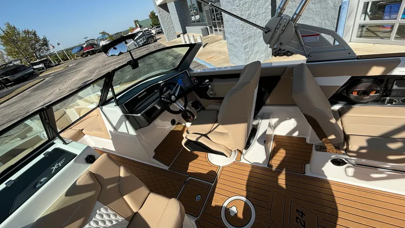 Slide: The Image of 2025 MasterCraft XT24 boat interior with tan seating and wood flooring. - 10