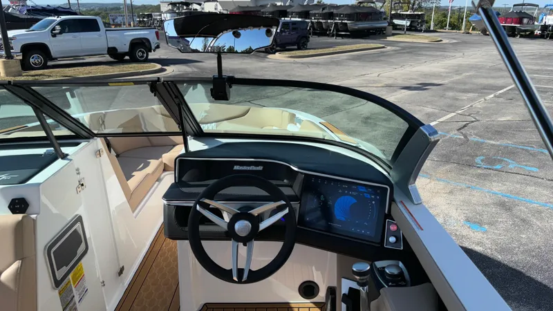 Slide: The Image of 2025 MasterCraft XT24 boat dashboard with steering wheel and digital display. - 13