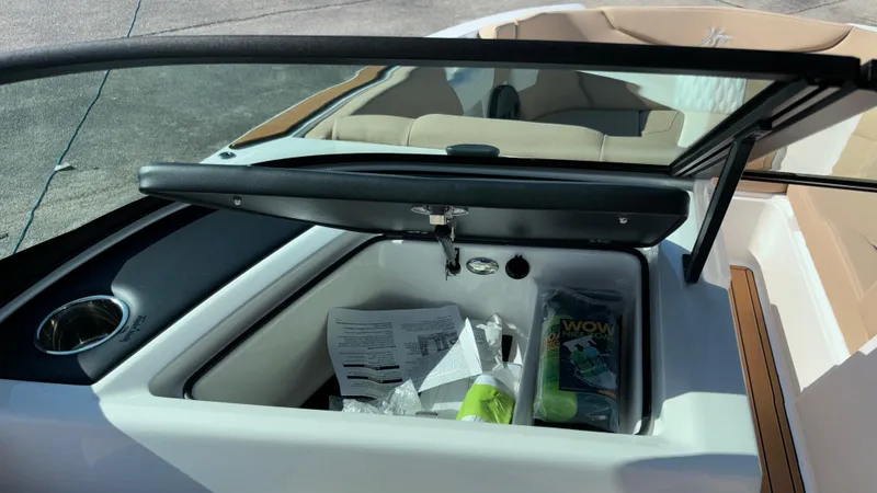 Slide: The Image of 2025 MasterCraft XT24 boat interior with open storage compartment and documents. - 15