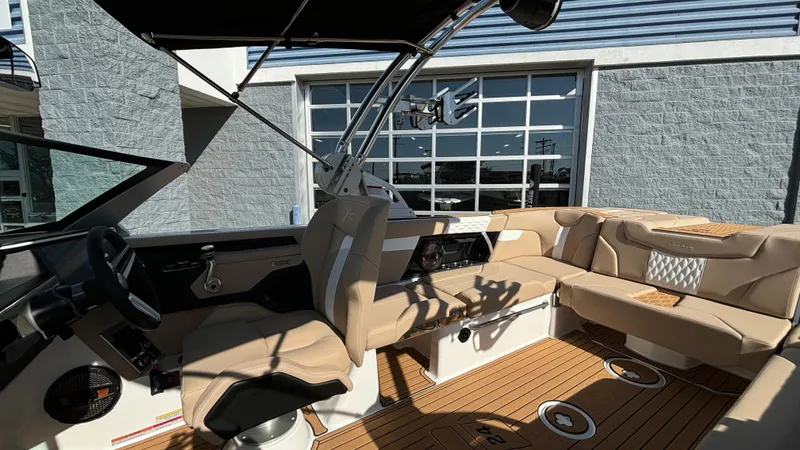 Slide: The Image of 2025 MasterCraft XT24 boat interior with beige seating and modern dashboard. - 16