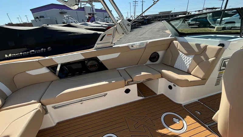 Slide: The Image of 2025 MasterCraft XT24 boat interior with tan seating and teak flooring. - 17